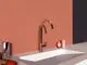 Küchenarmatur in Rosé-Tönen von Ideal Standard, mit eckigem Auslauf und moderner Form. Montiert an einer hellen Wand über einem weißen Spülbecken.